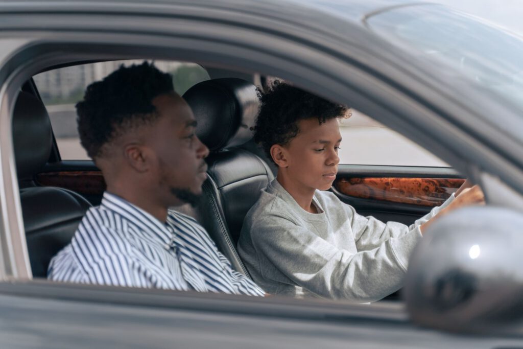 Élève au volant, accompagnateur assis à côté, vu par la vitre