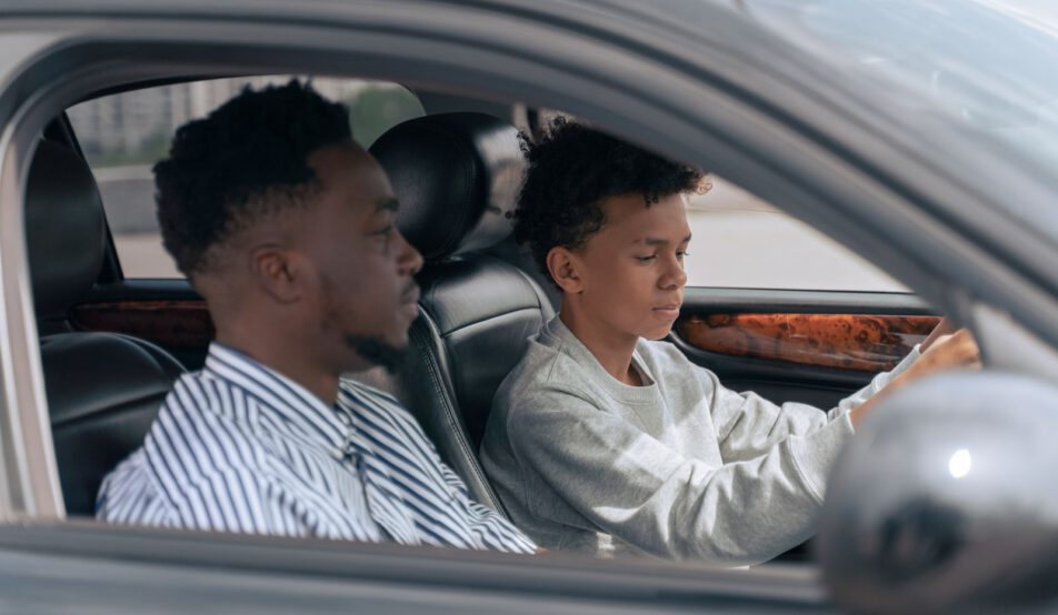 Élève au volant, accompagnateur assis à côté, vu par la vitre